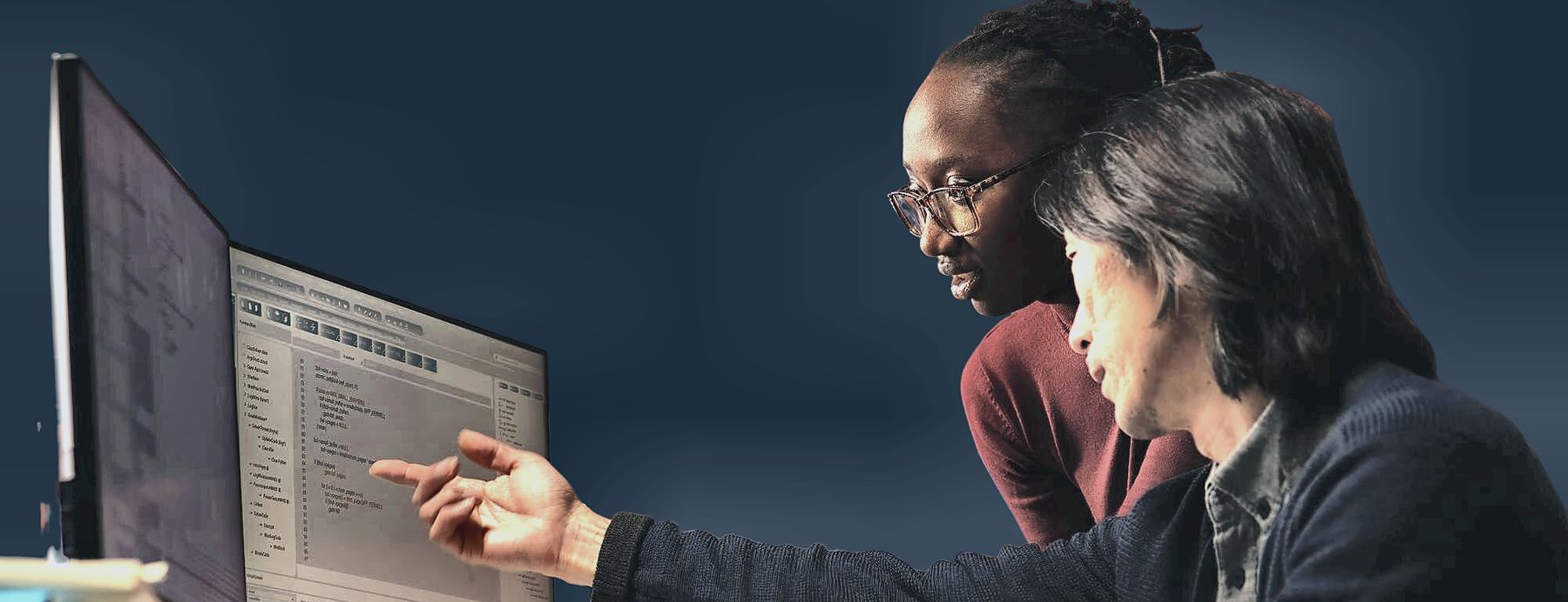 Two colleagues reviewing data on screen together
